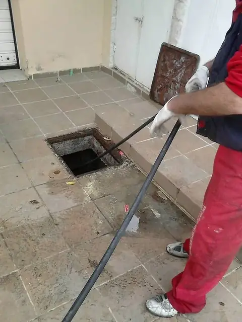 Τεχνικός καθαρίζει φρεάτιο με λάστιχο υδροβολής